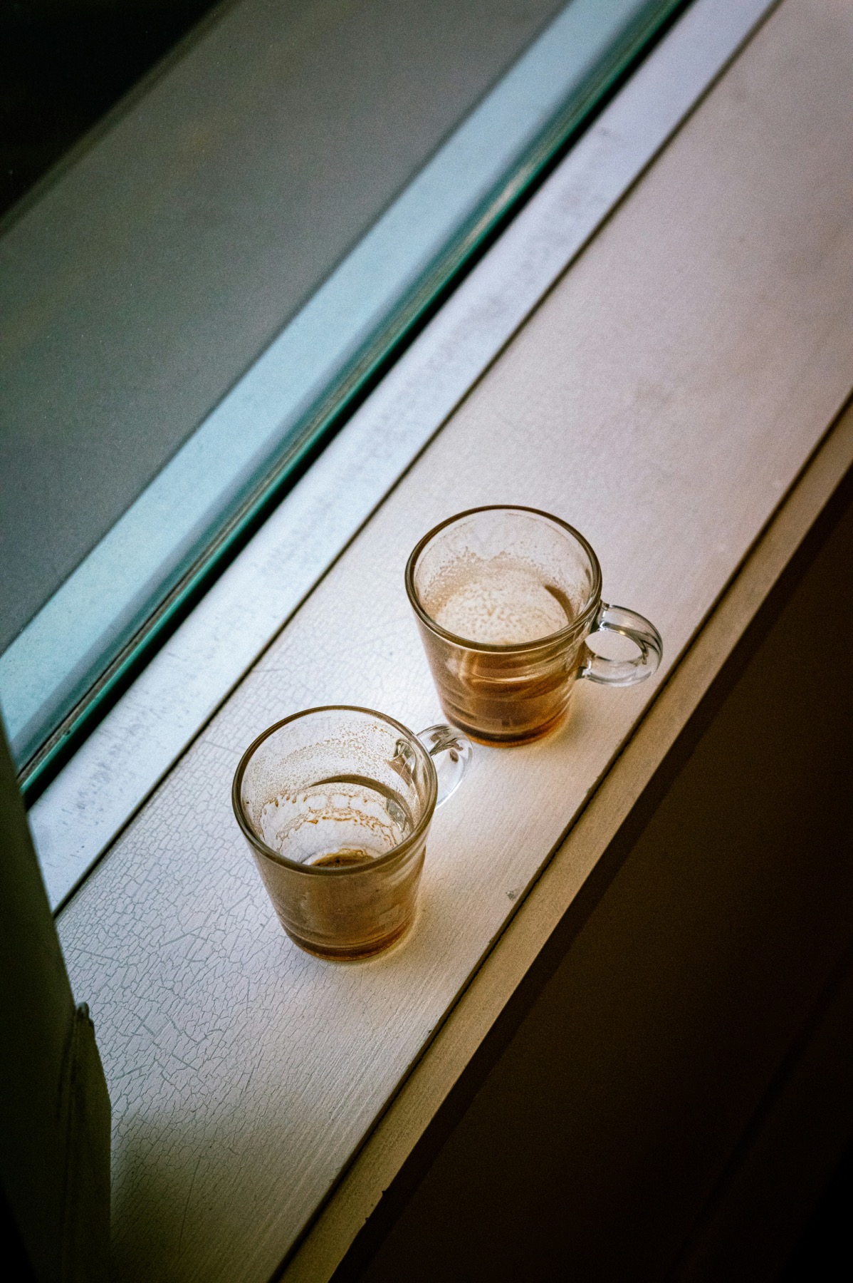 A quiet editorial relationship scene with two seats, a window, and a soft thread between them